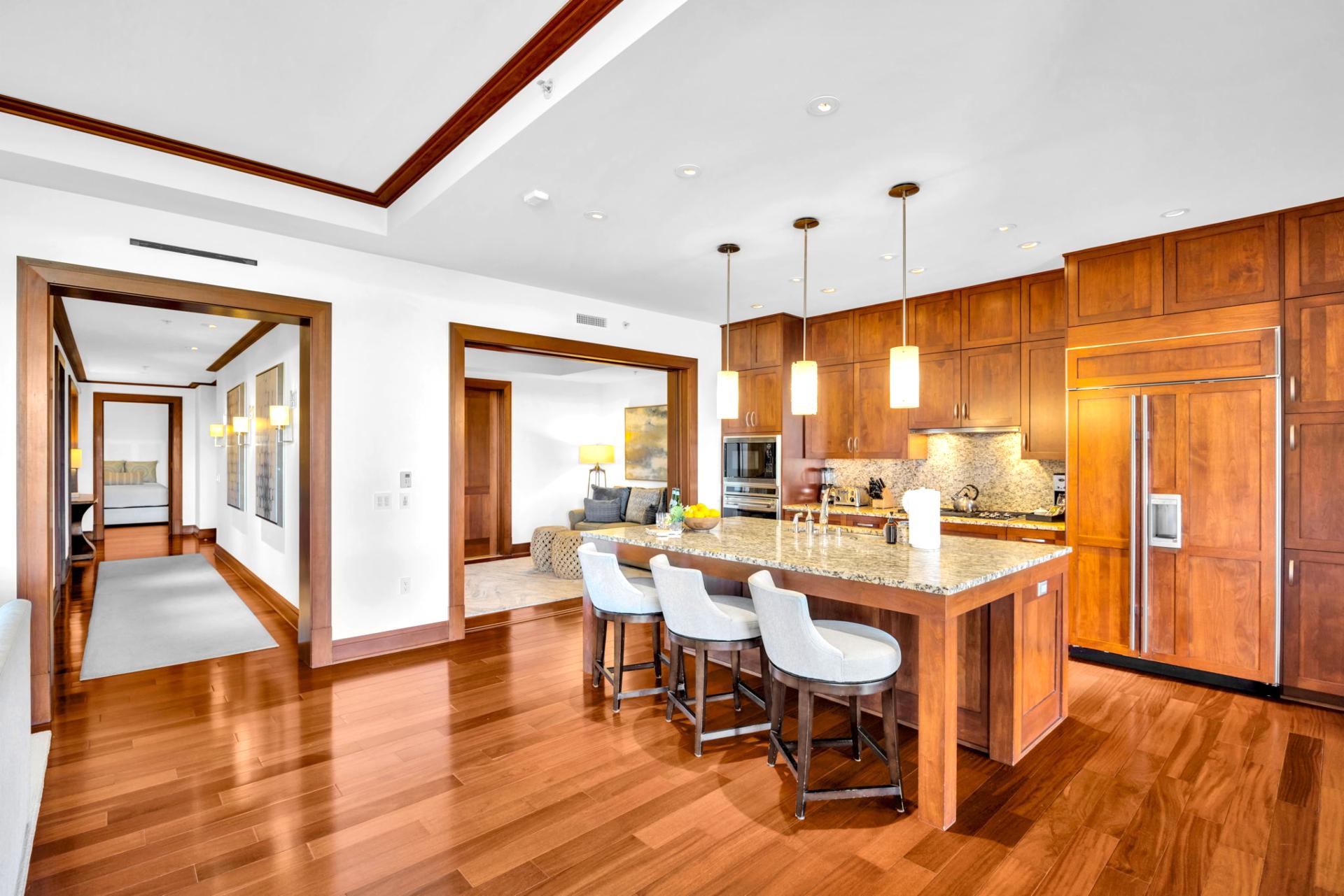 The gourmet kitchen features a granite top island with bar seating for three