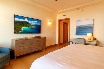 A serene master suite with a plush king bed opens to a private lanai, where comfort meets coastal sophistication