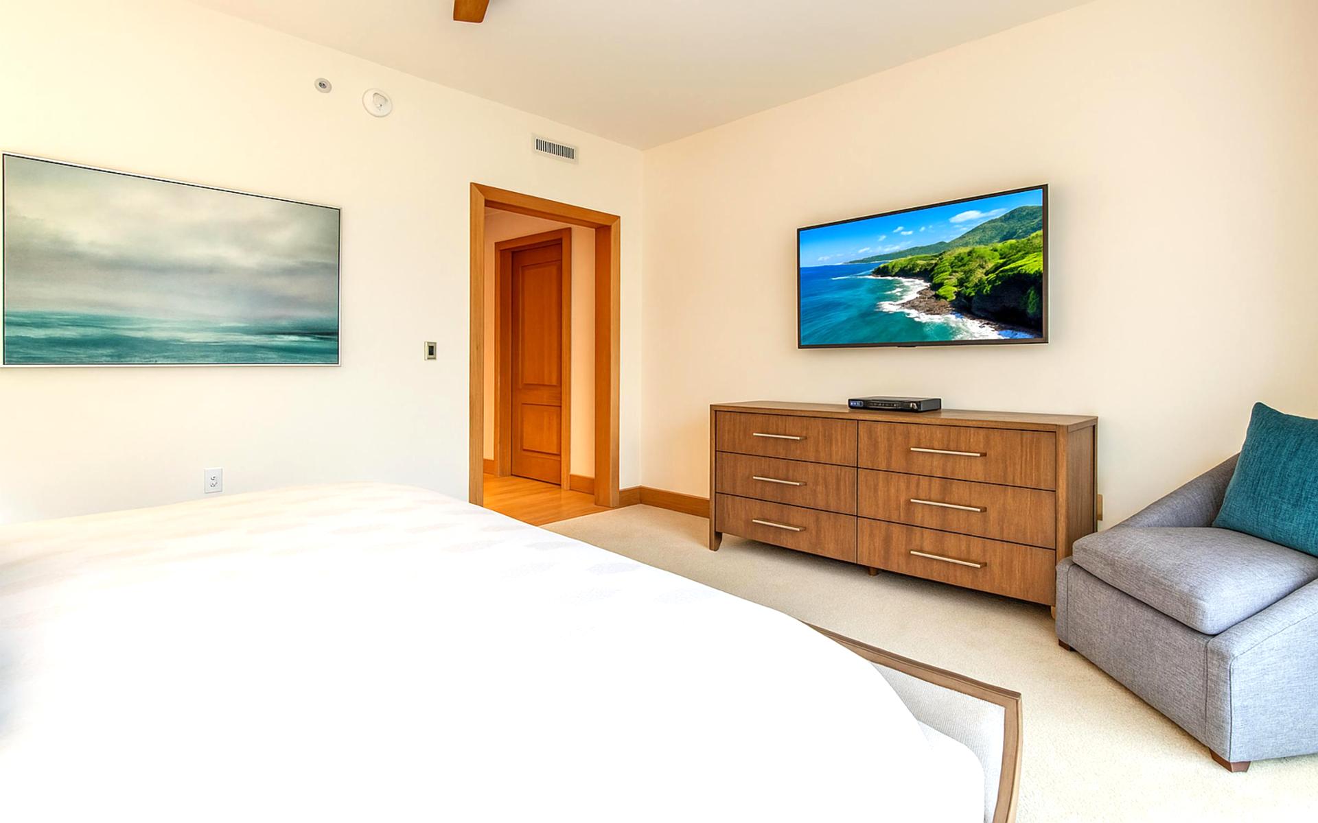 Gentle light filters through sheer drapes, casting soft shadows across the serene king-sized sleeping retreat