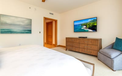 Gentle light filters through sheer drapes, casting soft shadows across the serene king-sized sleeping retreat