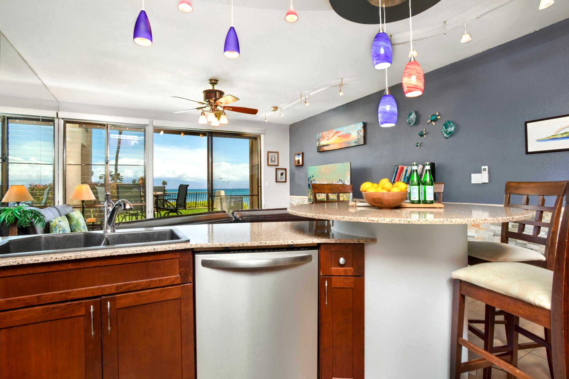 Modern coastal kitchen with ocean views, colorful pendant lighting, and island bar for relaxing tropical gatherings NAP-B26