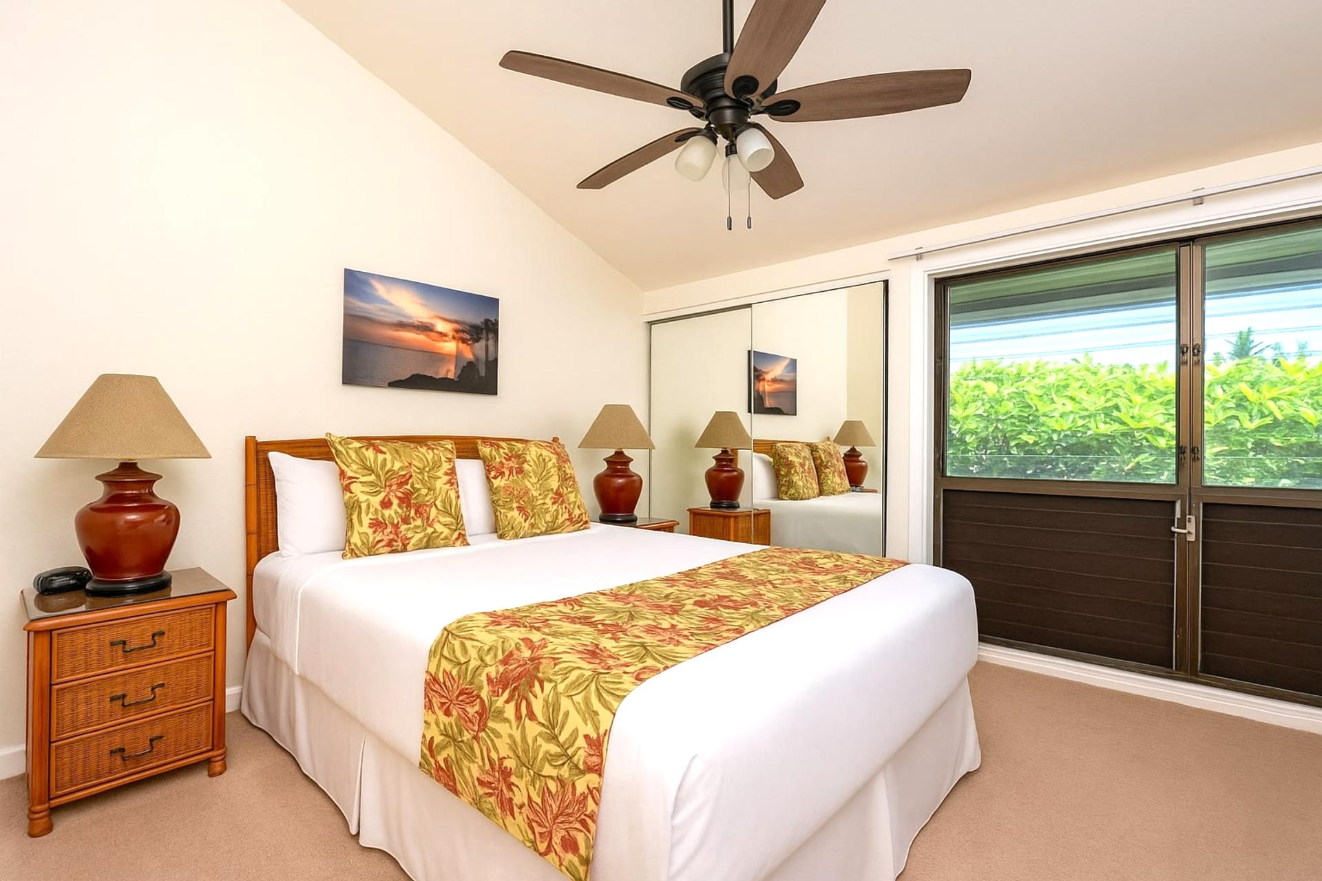 Relax in this warm master suite with vibrant accents, mirrored closet, ceiling fan, and lush window views