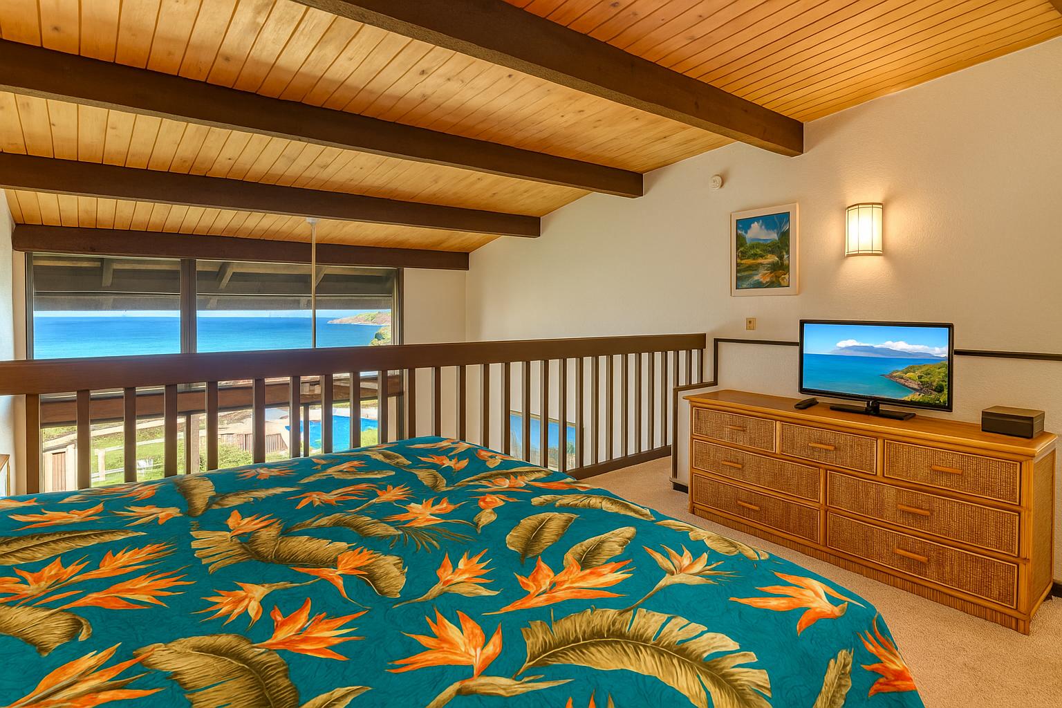Lofted master suite with rich wood ceilings, tropical bedding, natural light, and serene views from wide windows   NAP-C42