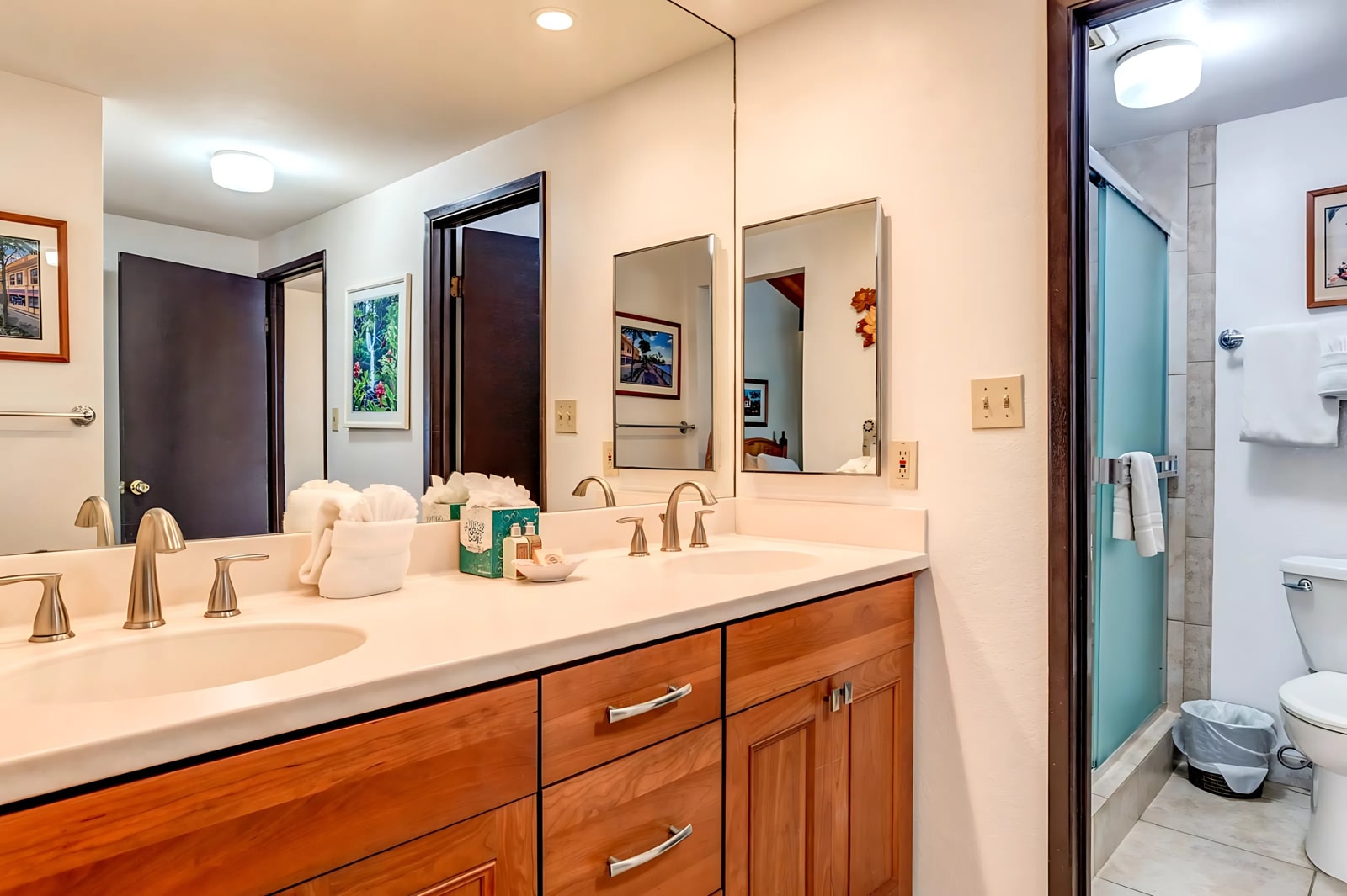 Framed art, warm wood cabinetry, and light-filled sightlines make this guest bath feel both inviting and tastefully styled NAP-C42