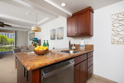 Warm wood, golden granite, and stainless sparkle, this chic kitchen feels like a recipe kissed by island sunshine