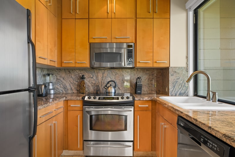 Sleek and functional kitchen space with granite countertops and warm wood cabinetry