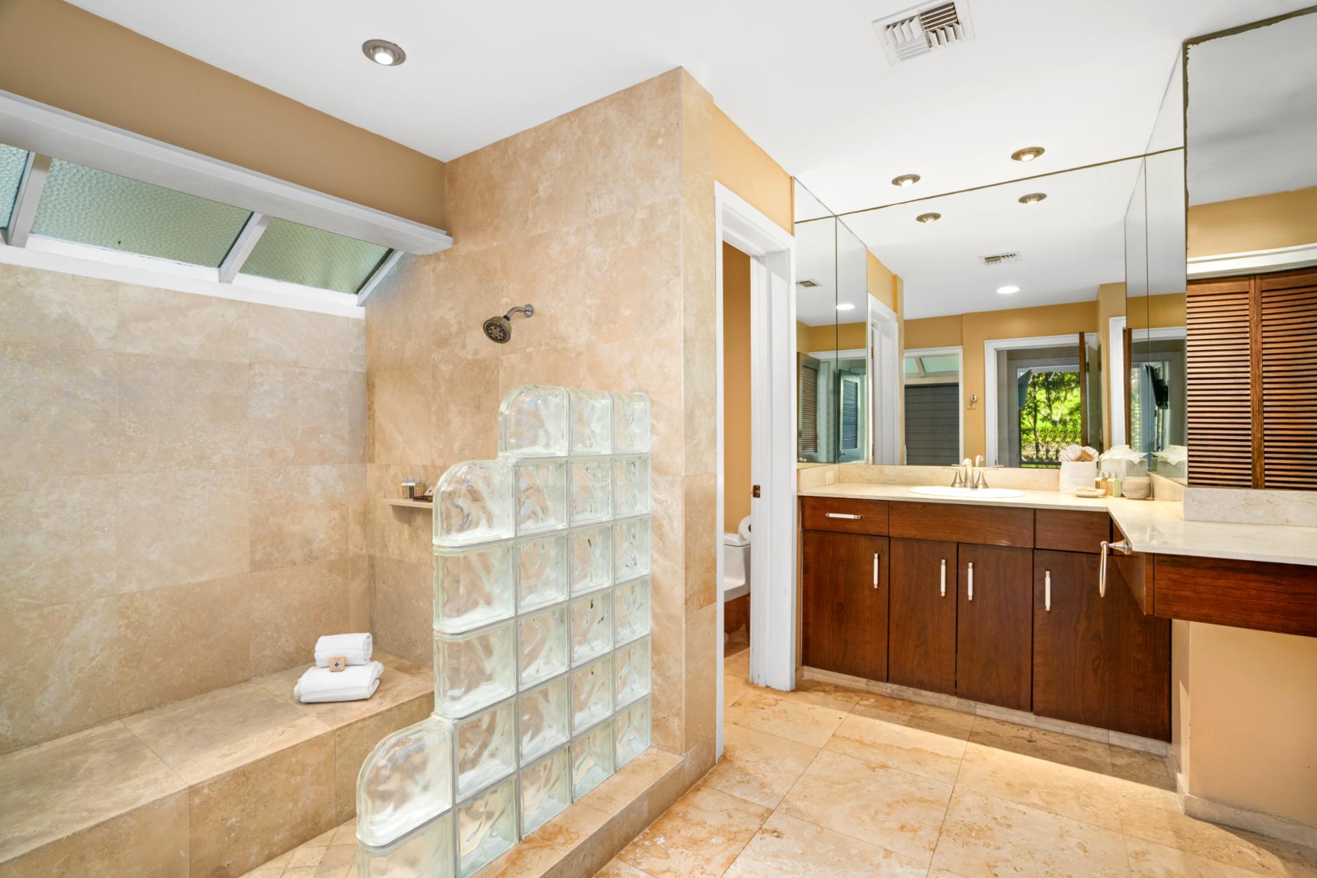 Refresh in a serene bathroom retreat with a glass block shower and modern vanity
