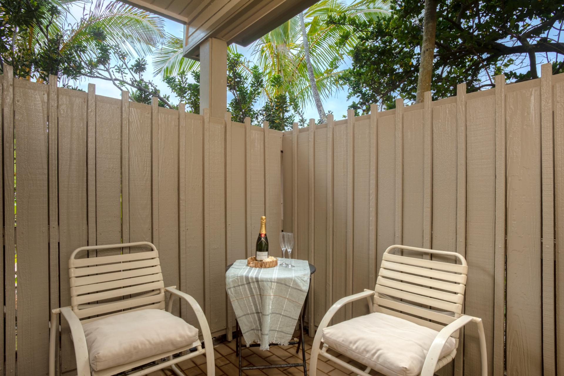Savor your morning coffee or evening drink in this private outdoor nook surrounded by greenery