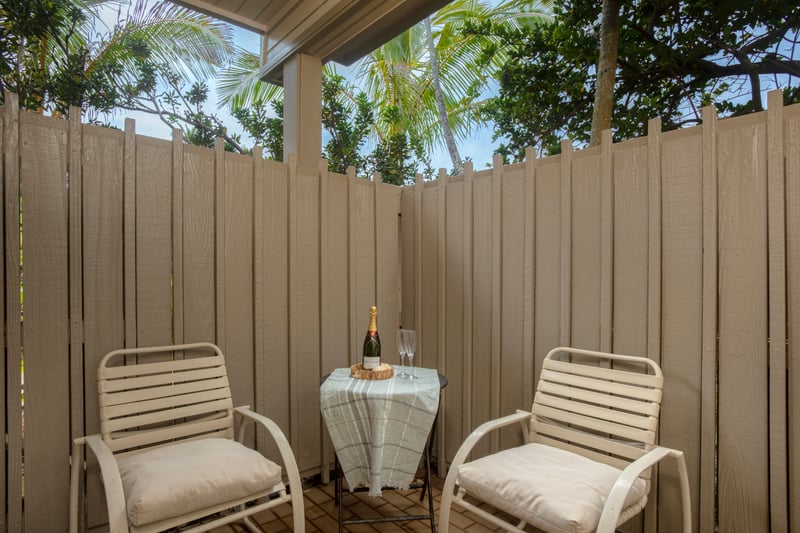 Savor your morning coffee or evening drink in this private outdoor nook surrounded by greenery