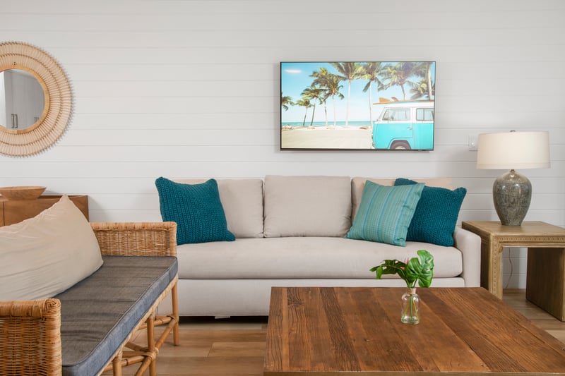 This living room is like a beach day in furniture form—bright, easygoing, and never without a splash of teal