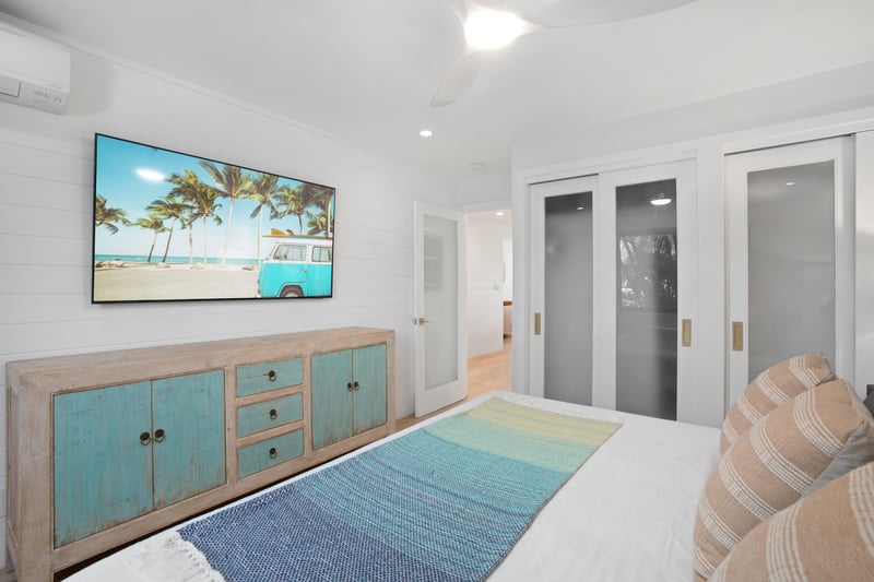 This master bedroom is a palette of seafoam and sand, anchored by a king bed as wide as a beachside hammock dream