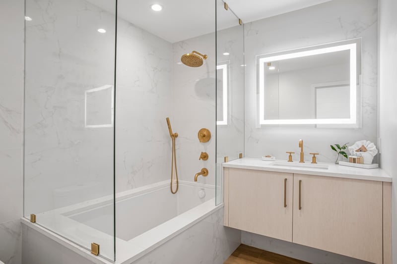 Step into a cloud of white marble dreams, where brushed gold fixtures gleam like hidden treasure in a luxe lagoon