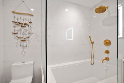 Gold shower knobs line the wall like precious buttons on a royal uniform—commanding comfort with every turn