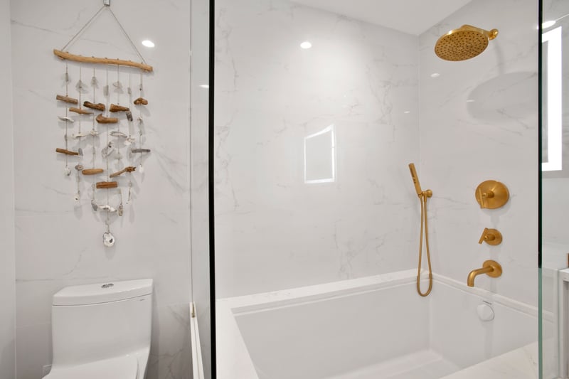 Gold shower knobs line the wall like precious buttons on a royal uniform—commanding comfort with every turn