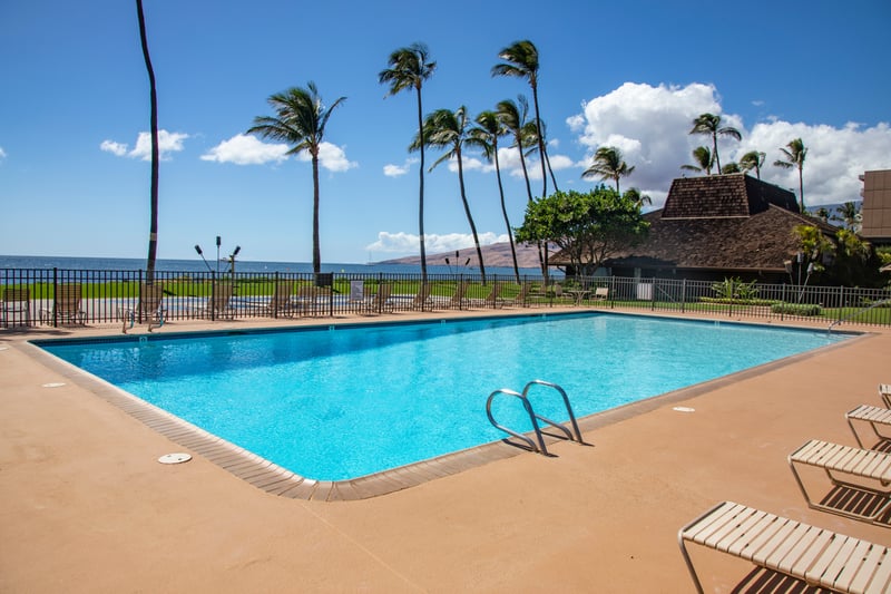 Step into this sunlit sanctuary where the pool shimmers like liquid sapphire, framed by palms that dance in ocean breezes