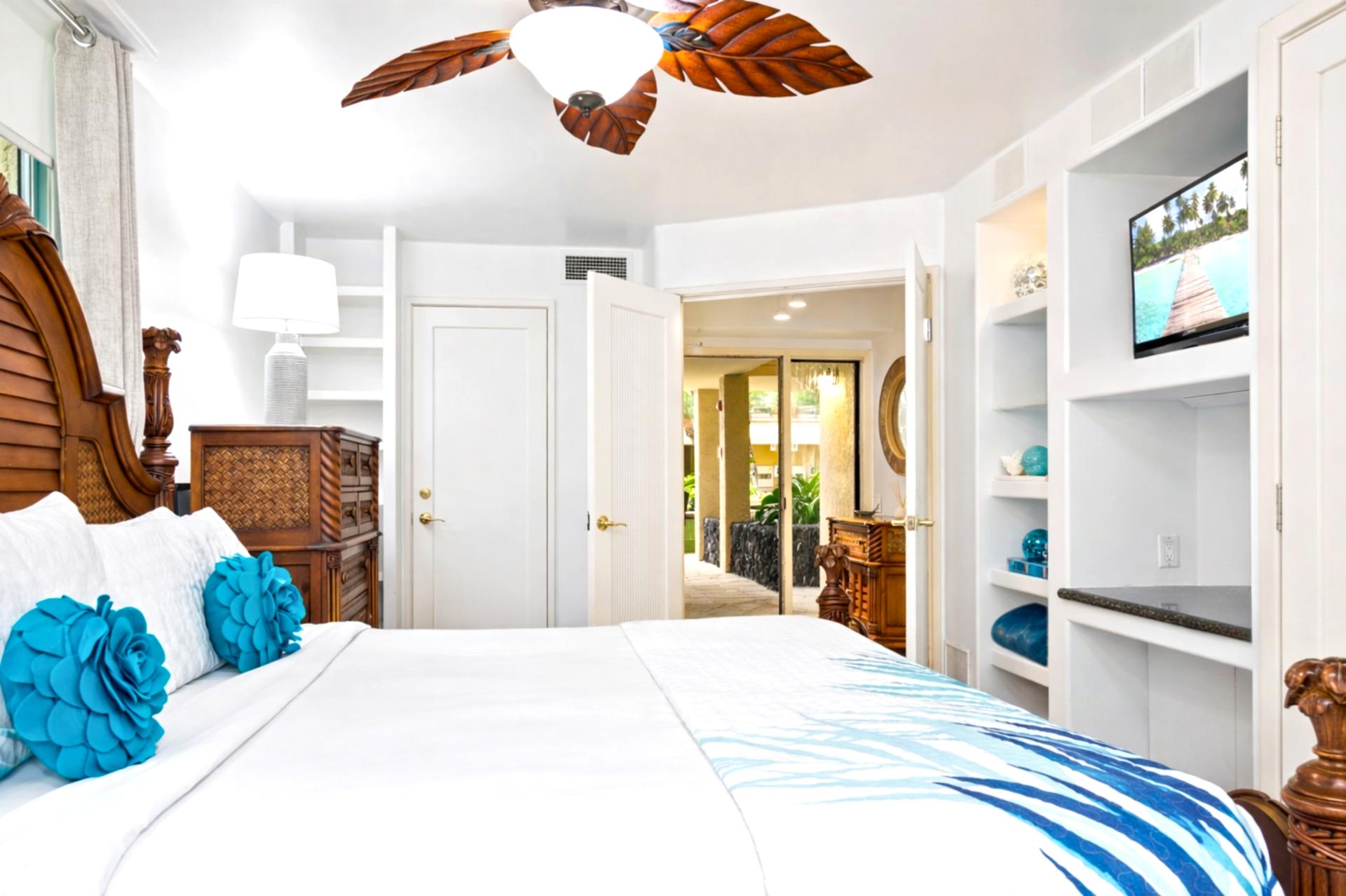 Retreat to the master bedroom featuring a luxurious king-size bed, ceiling fan, and cozy island decor. Wake up to serene views just beyond your windows.