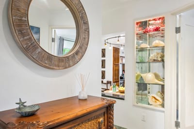 Step into your island escape through a beautifully maintained entrance surrounded by lush landscaping and welcoming touches.