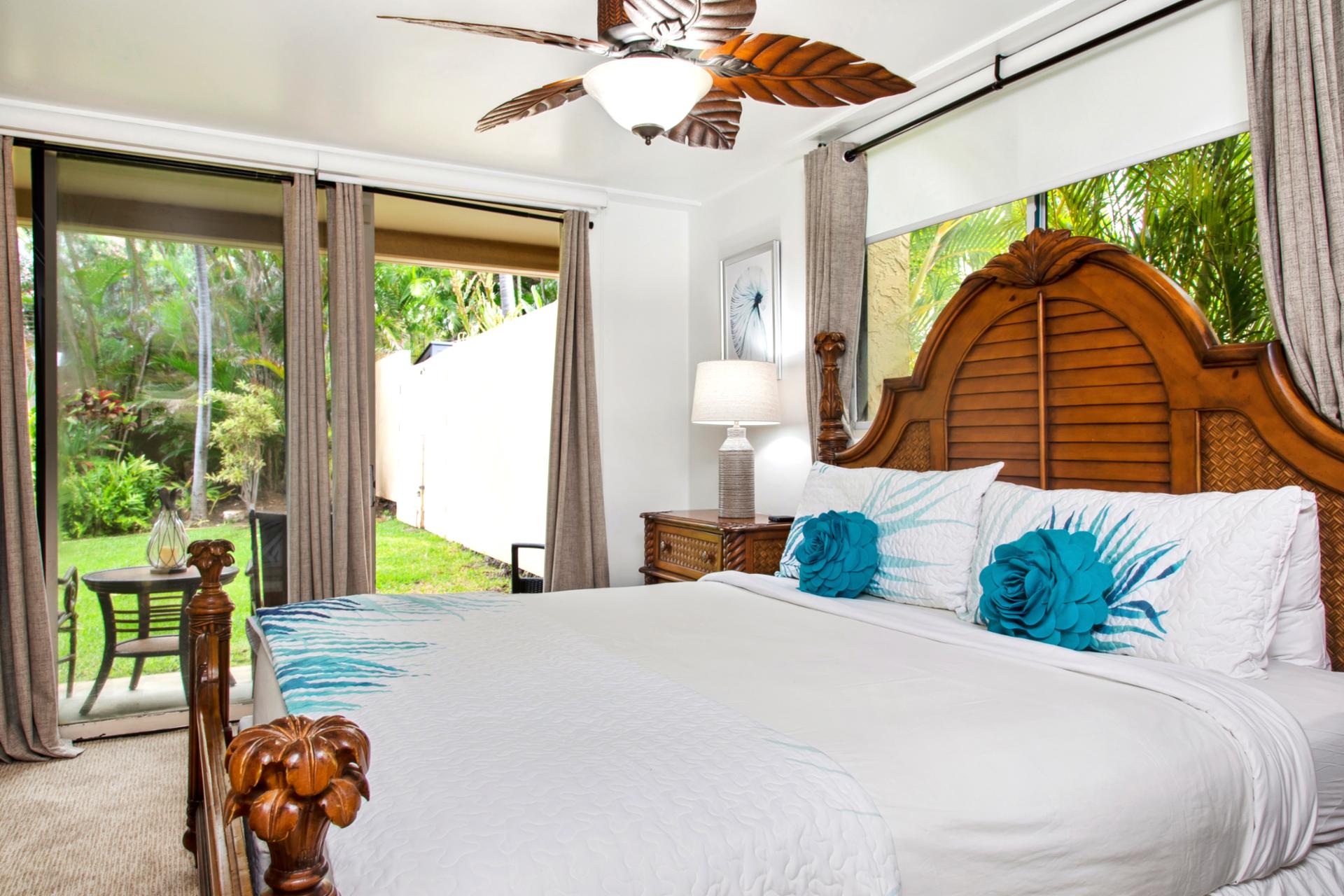 Retreat to the master bedroom featuring a luxurious king-size bed, ceiling fan, and cozy island decor. Wake up to serene views just beyond your windows.