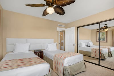 A palm-frond ceiling fan flutters overhead, blessing the twin beds with breezes straight from a postcard