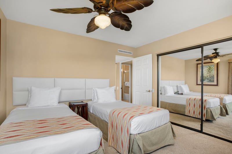 A palm-frond ceiling fan flutters overhead, blessing the twin beds with breezes straight from a postcard
