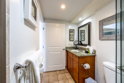 A spacious and spotless bathroom with ample storage, granite vanity, and elegant coastal touches.