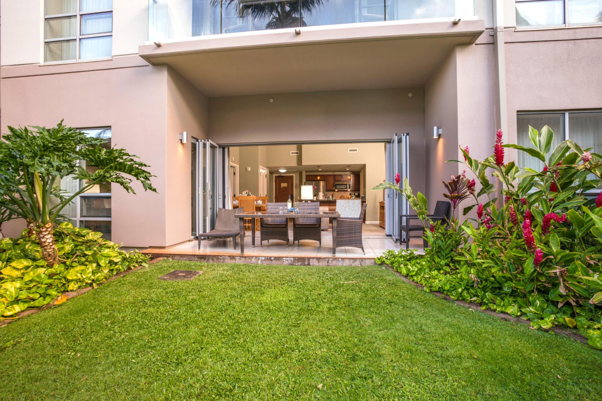 Spacious ground-level lanai opens to a lush private yard, seamlessly blending indoor comfort with tropical outdoor living.