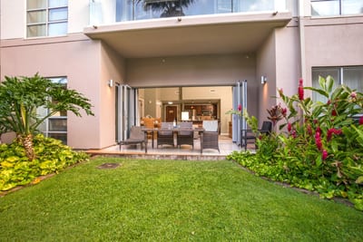 Spacious ground-level lanai opens to a lush private yard, seamlessly blending indoor comfort with tropical outdoor living. HKH-114