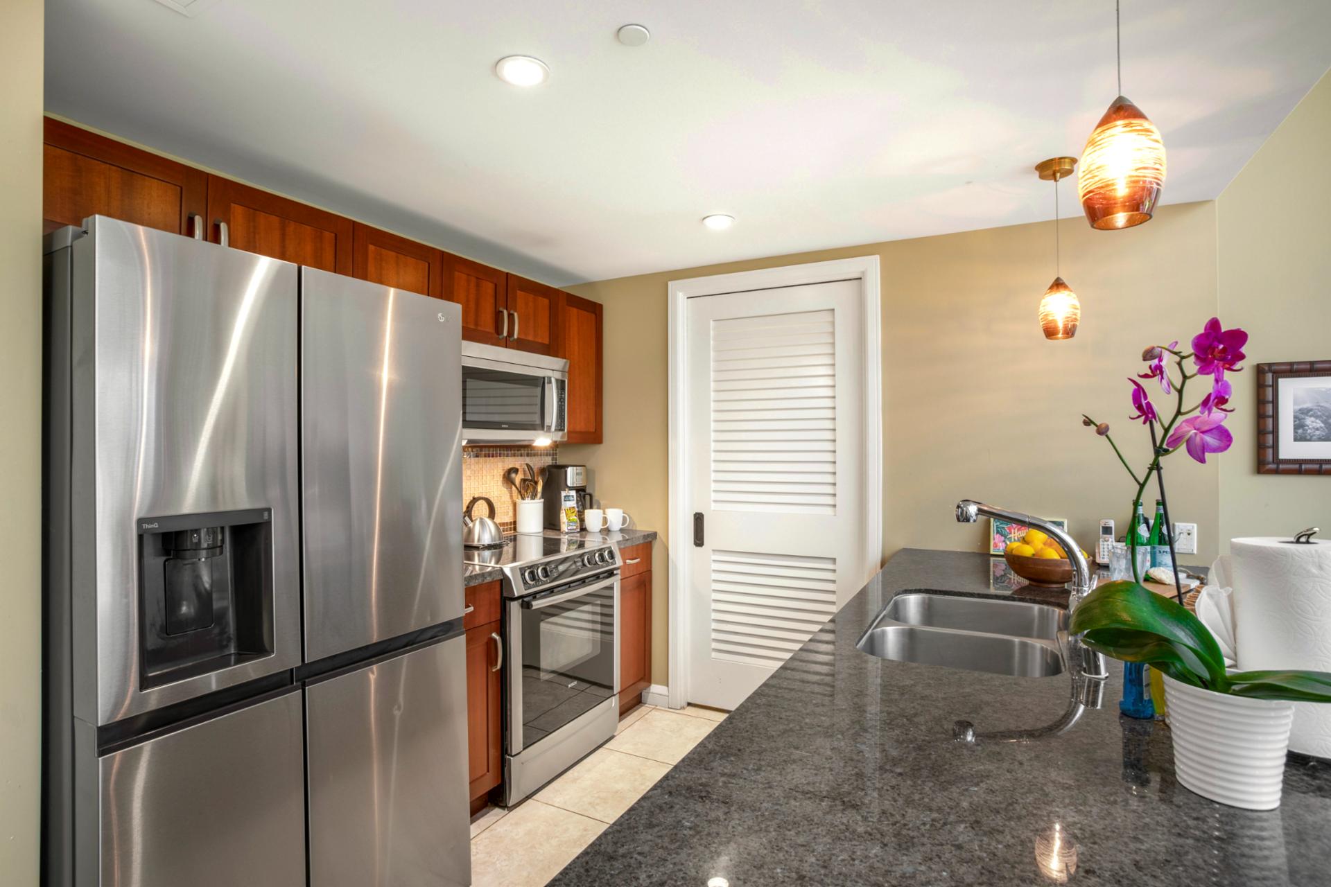 Modern kitchen with granite countertop and stainless steel appliances. 
