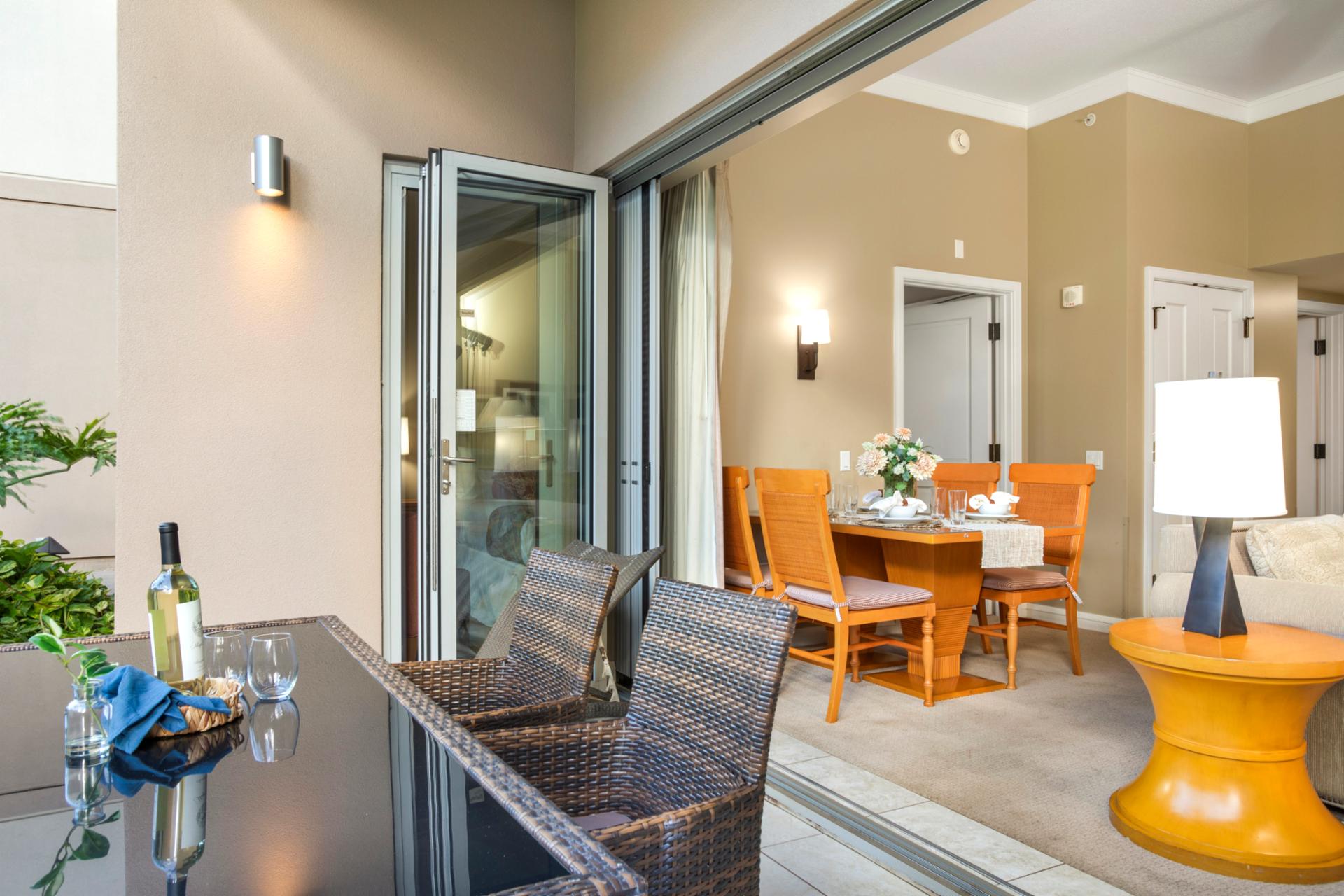 Seamless indoor-outdoor living with sliding glass doors connecting the cozy lanai to a beautifully set dining area