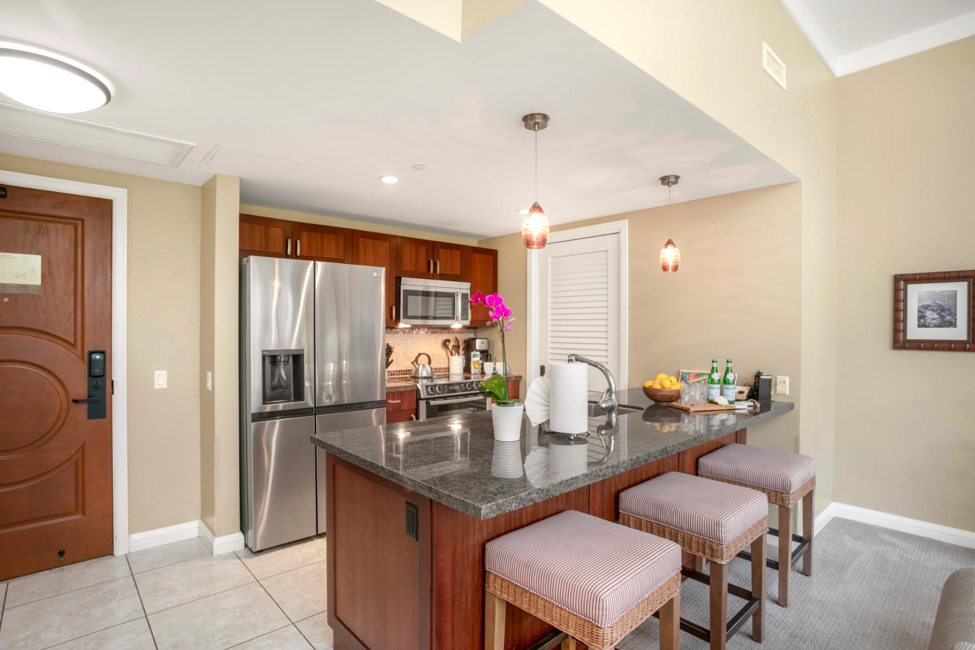 Stylish gourmet kitchen with granite countertops, stainless steel appliances, and bar seating