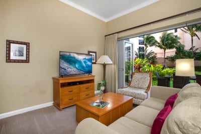 Charming and airy living room with rich wood furnishings, island-inspired decor, and lush garden views HKH-114