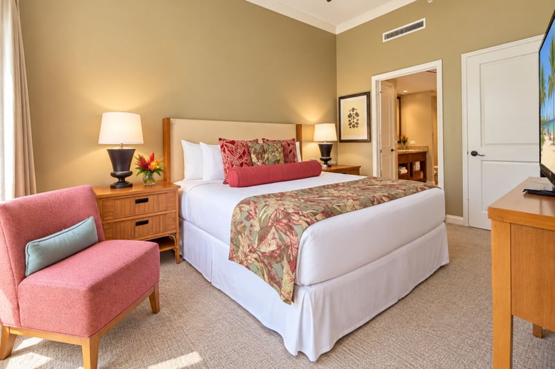 Retreat to the spacious Primary Bedroom featuring a plush bed, a cozy reading chair, and direct outdoor access. HKH-114