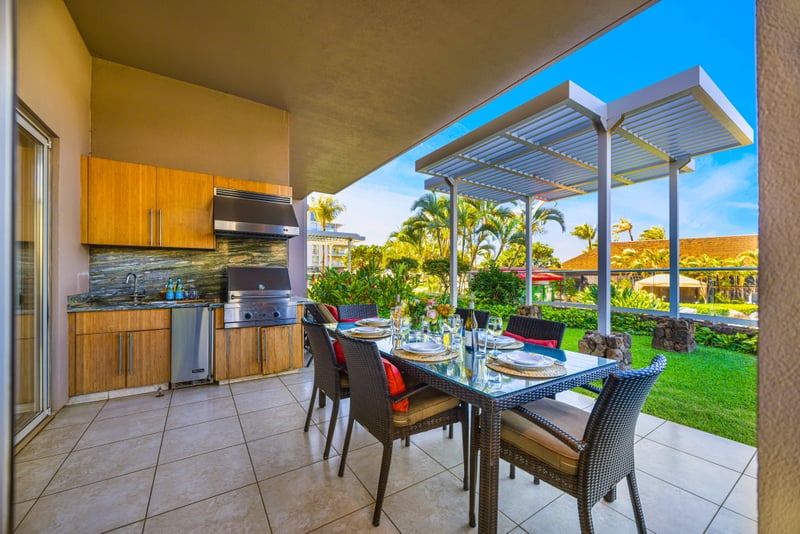 Outdoor kitchen at Honua Kai HKH-150 — built-in BBQ grill and dining table beneath the private garden pergola