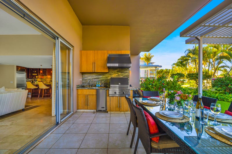 Outdoor BBQ kitchen at Honua Kai Hokulani 150 — full grill station with granite counters, sink, and wine fridge just off the lanai dining table