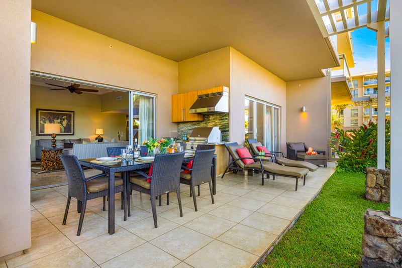 Covered lanai at Honua Kai HKH-150 — full outdoor living space with BBQ kitchen, dining for six, and lounge seating opening to the living room