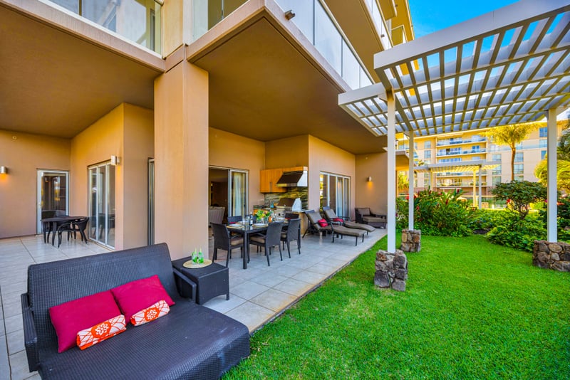 Living room at Honua Kai HKH-150 — smart TV, tropical artwork, and comfortable seating for the whole group