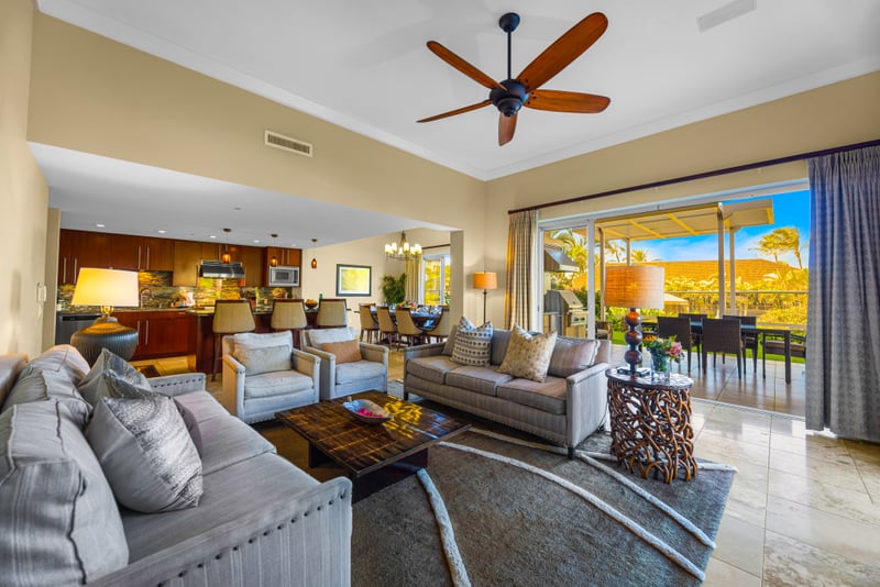 Living room at Honua Kai HKH-150 — sliding doors open directly to the lanai, BBQ kitchen, and garden