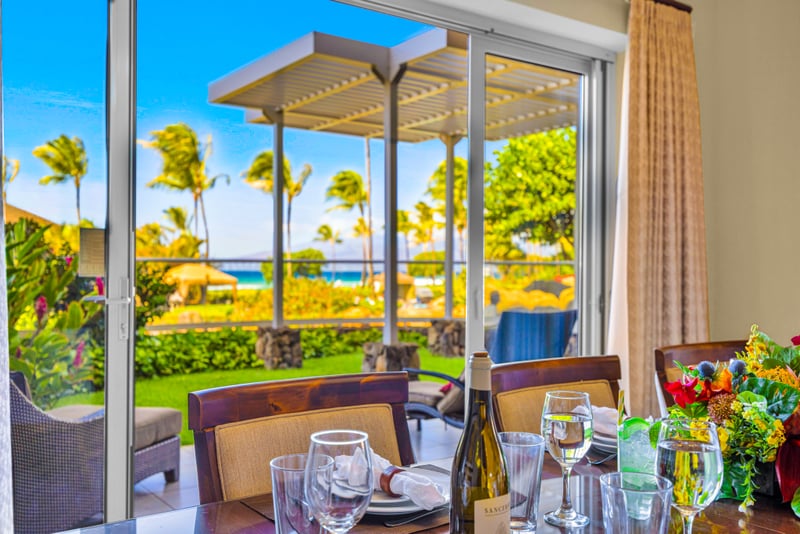 Oceanview dining at Honua Kai HKH-150 — private lanai table set with wine, framed by the pergola and Pacific horizon