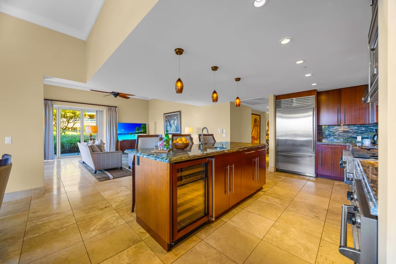 Chef's kitchen at Honua Kai Hokulani 150 — Sub-Zero refrigerator, wine fridge, and a granite island open to the living area
