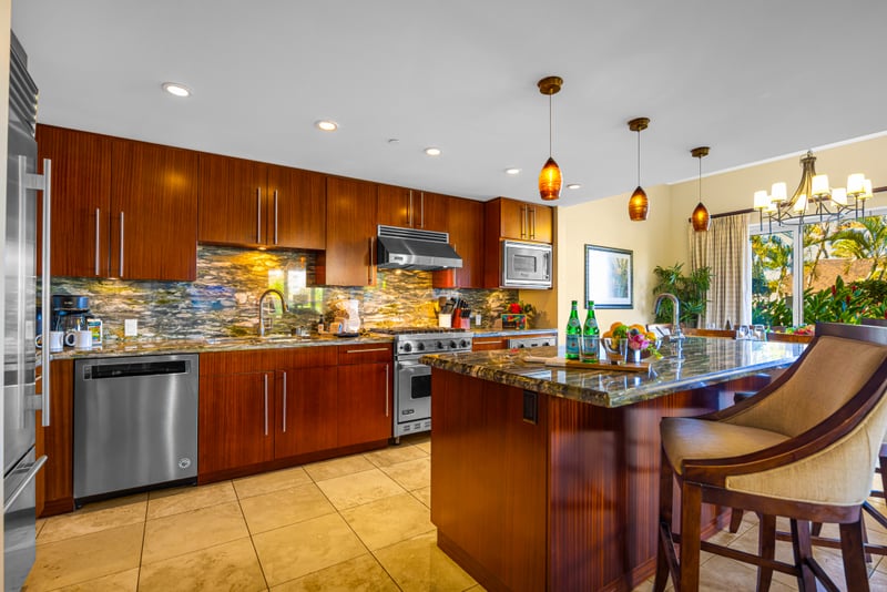 Kitchen at Honua Kai HKH-150 — Sub-Zero refrigerator and granite counters opening to the living room beyond