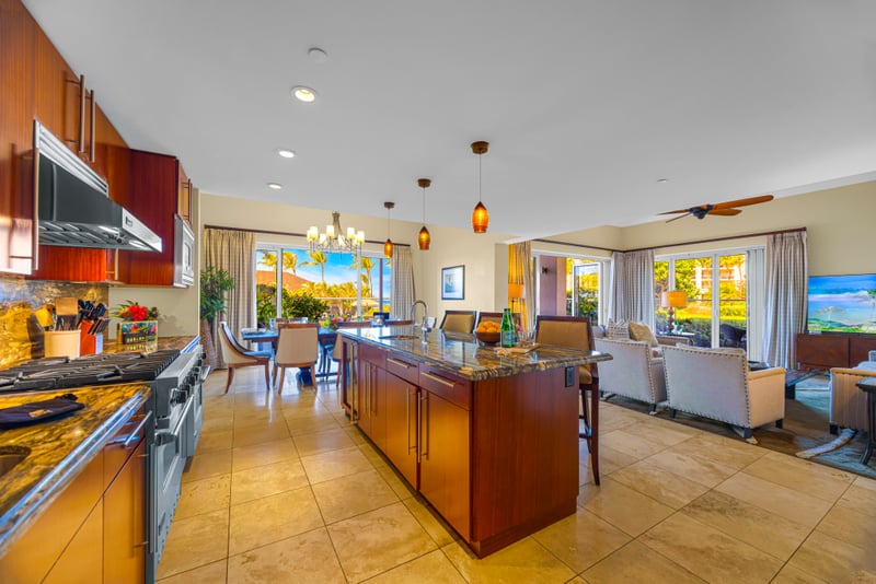 Open-concept kitchen, dining, and living room at Honua Kai HKH-150 — seamless entertaining from cooktop to garden-view dining table