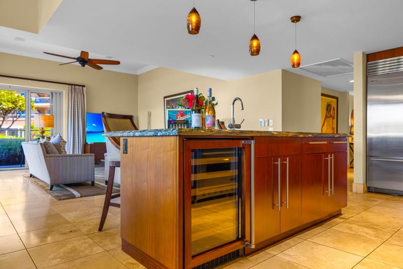 Kitchen wine bar at Honua Kai HKH-150 — built-in wine fridge and pendant lighting beside the Sub-Zero refrigerator