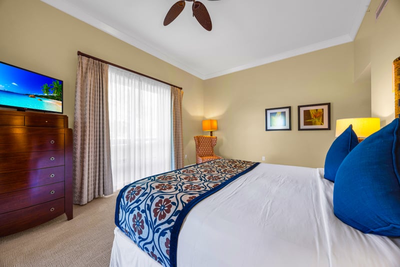 Guest bedroom at Honua Kai HKH-150 — smart TV and blue accent pillows for a restful stay