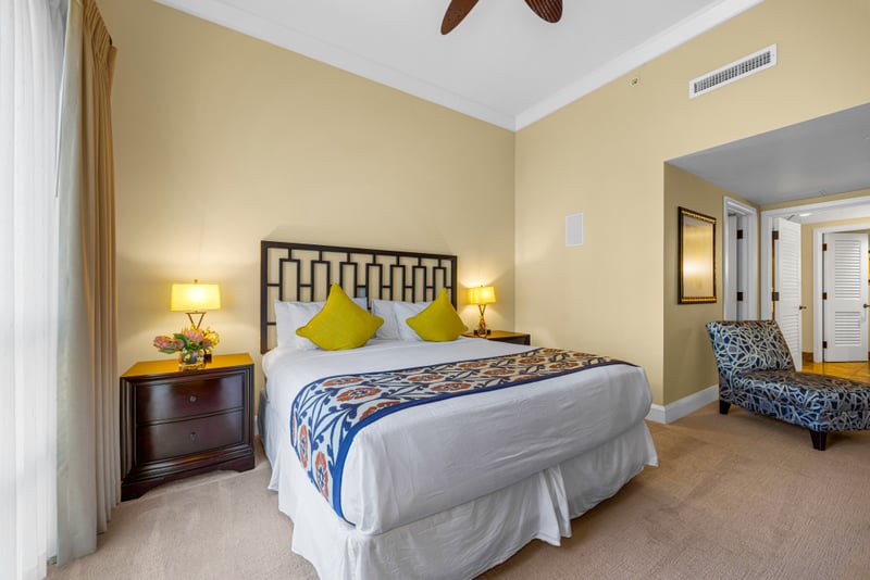 Guest bedroom at Honua Kai HKH-150 — king bed with chartreuse pillows and a sculpted metal headboard