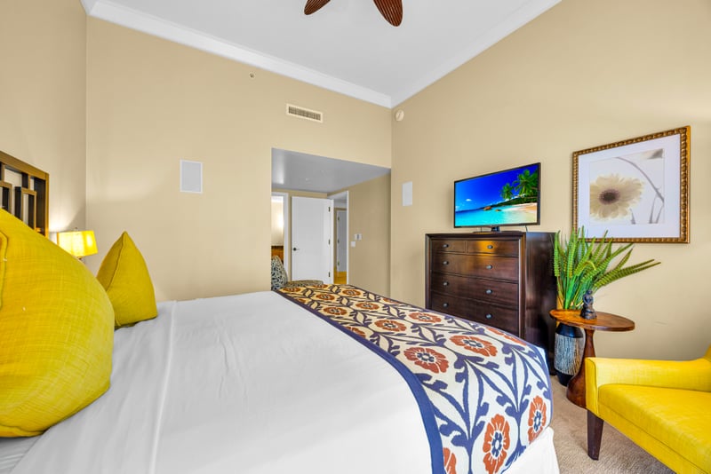 Guest bedroom at Honua Kai HKH-150 — king bed, smart TV, and a bright island color palette