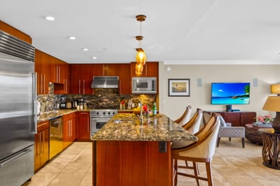 Warm wood cabinetry, stone countertops, and a wide prep island make cooking easy and social.