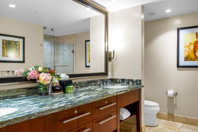 Your spacious primary bath features a granite dual vanity, walk-in shower, and soaking tub stocked with L’Occitane amenities.