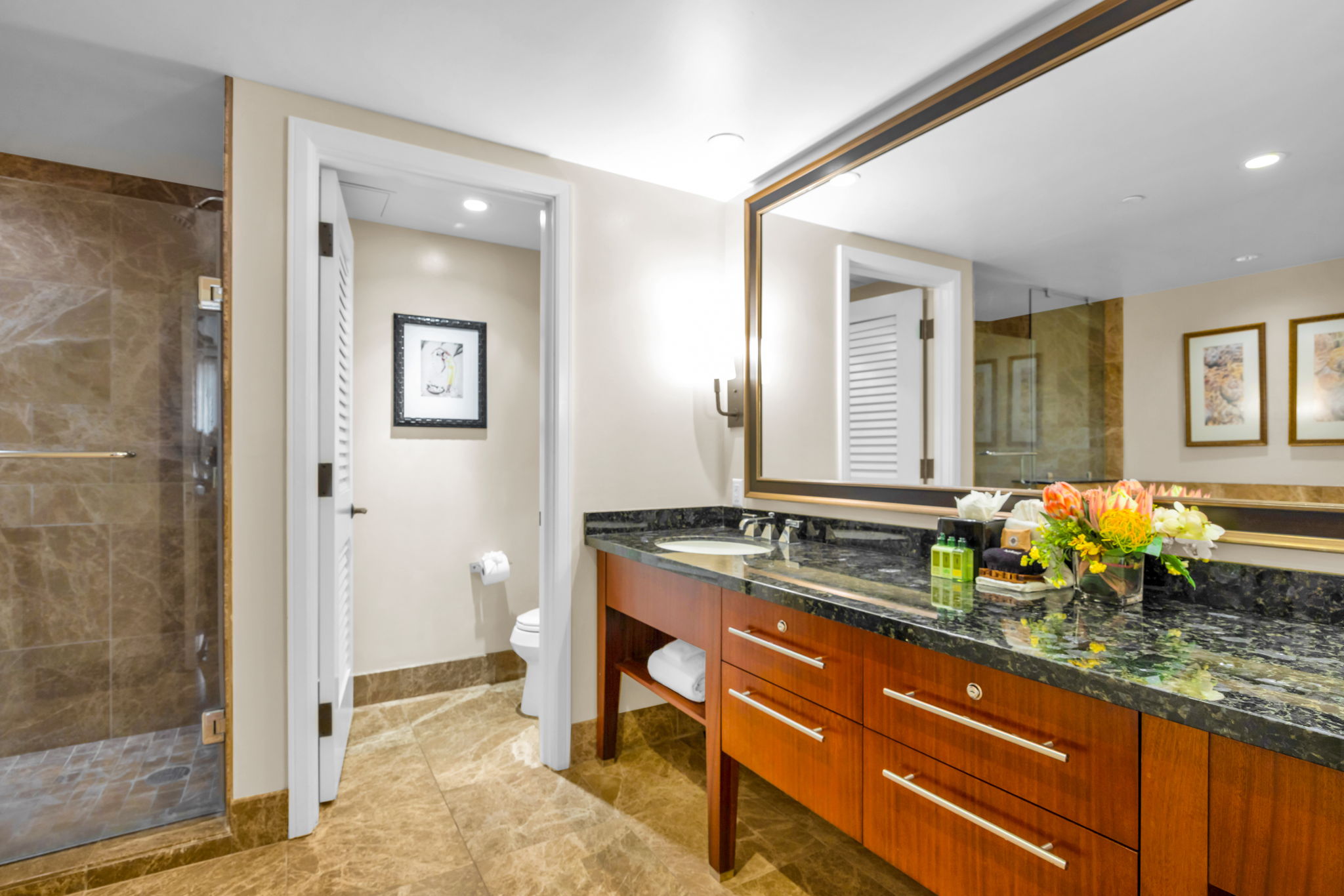 This guest bathroom connects conveniently to the hall, with generous counter space and warm lighting.