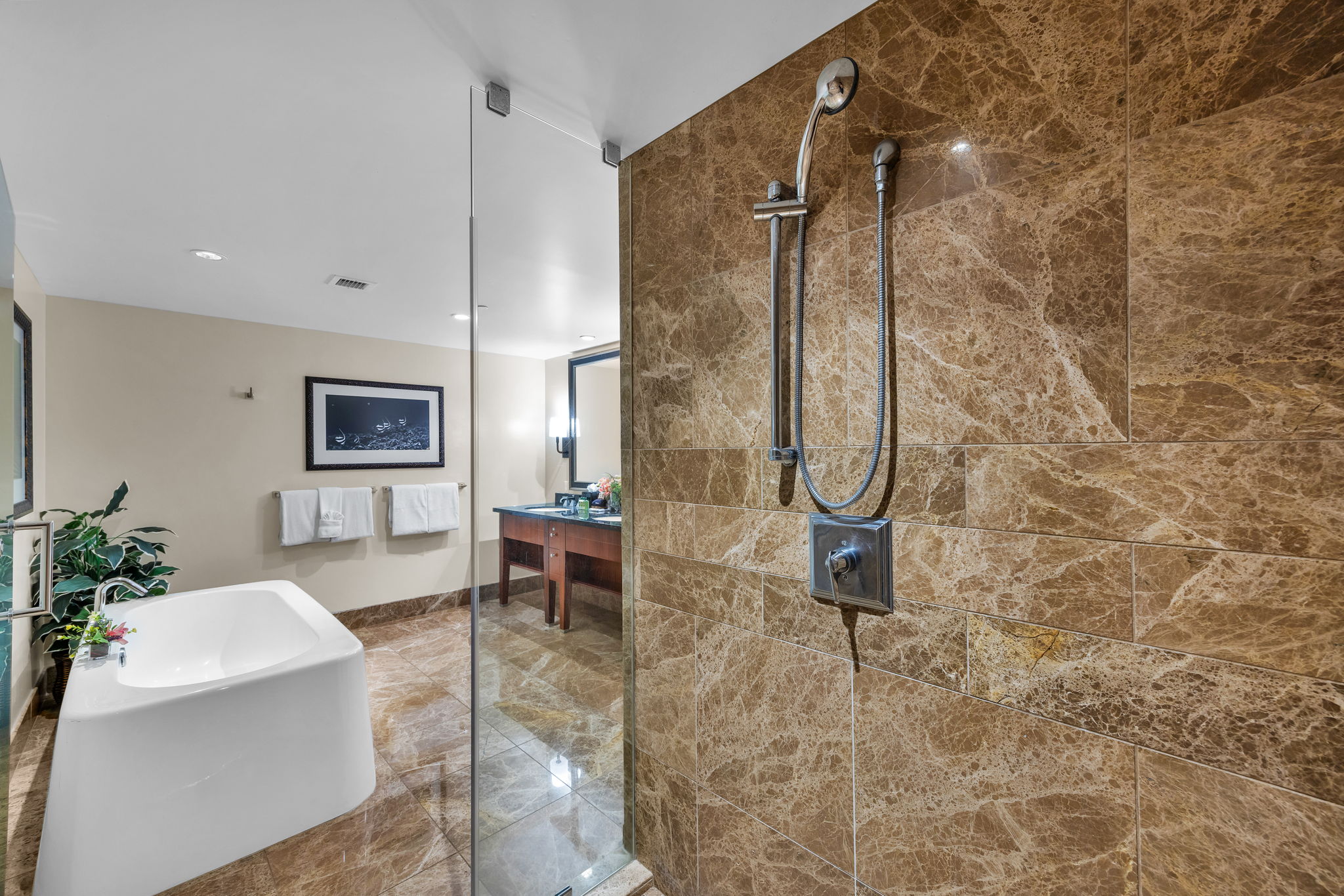 This bathroom includes a walk-in shower, soaking tub, and spacious layout for added privacy and ease.