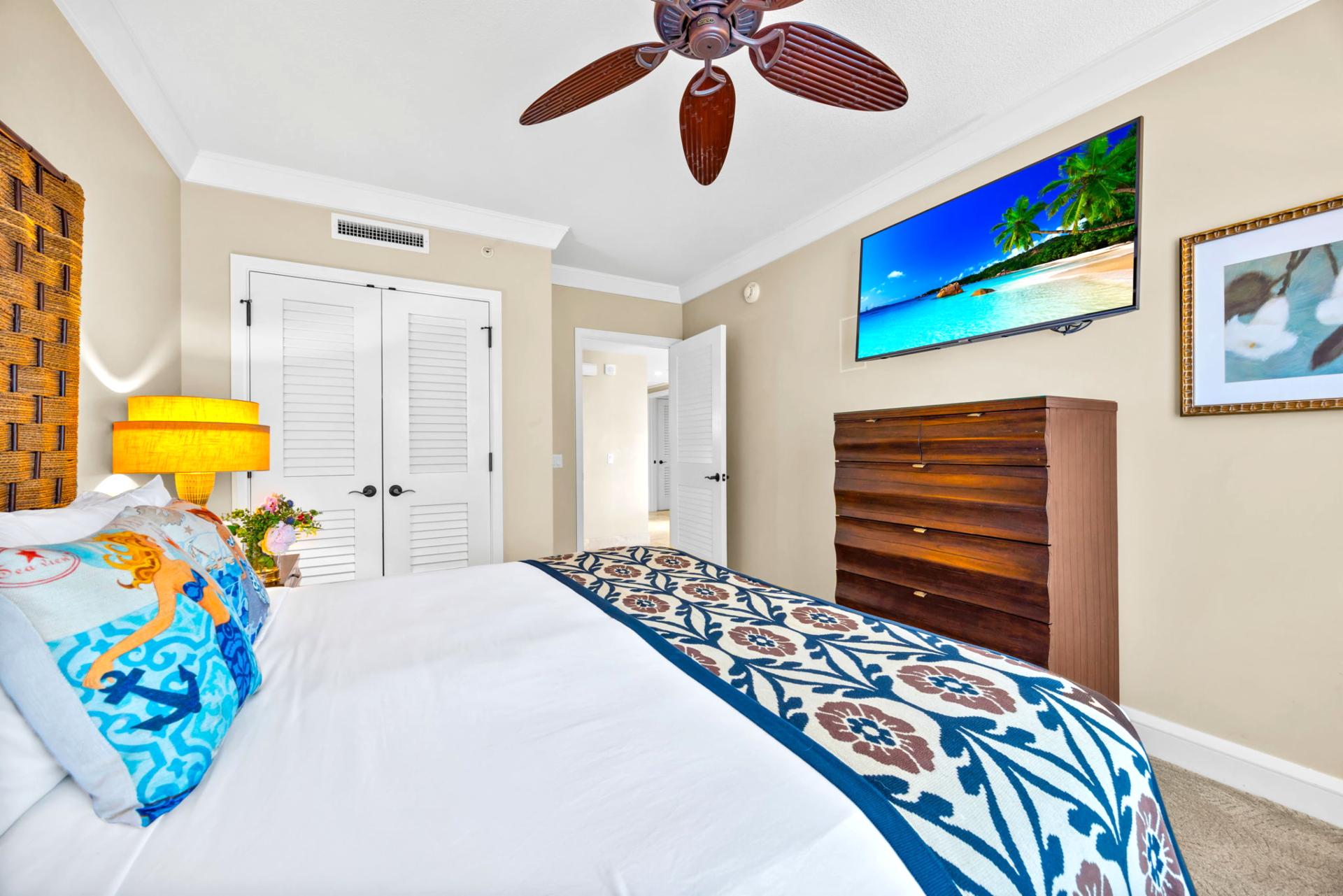 Primary bedroom features a plush King bed, 55" Smart TV, and peaceful garden views. HKH-203